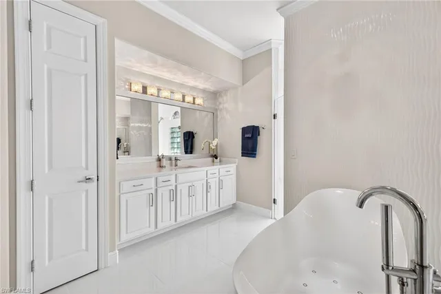 a spacious bathroom with a double vanity sink mirror and bathtub