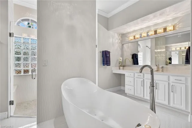a bathroom with a double vanity sink mirror and bathtub