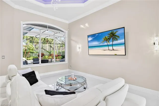 a view of a dining room with furniture a large window and a chandelier