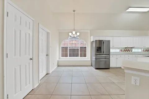 a view of a kitchen with dishwasher and white cabinets
