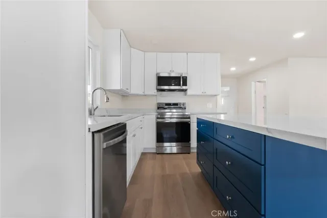 a kitchen with stainless steel appliances granite countertop a stove a sink and a microwave