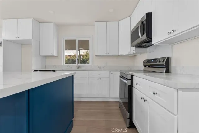 a kitchen with white cabinets stainless steel appliances and a sink