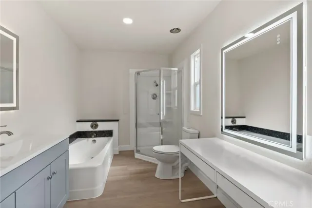 a bathroom with a sink vanity granite toilet and a mirror