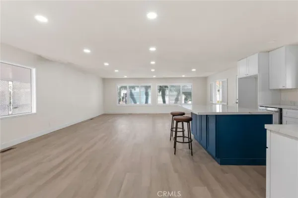 a living room with lots of furniture and kitchen view