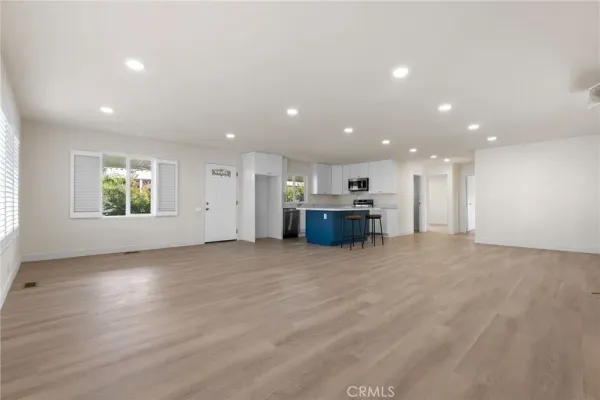 a view of kitchen and kitchen with stainless steel appliances wooden floor