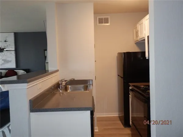 a kitchen with a refrigerator and a sink