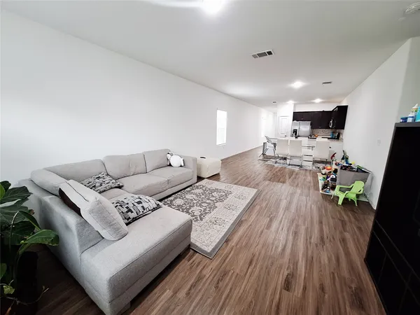 a living room with furniture and a wooden floor