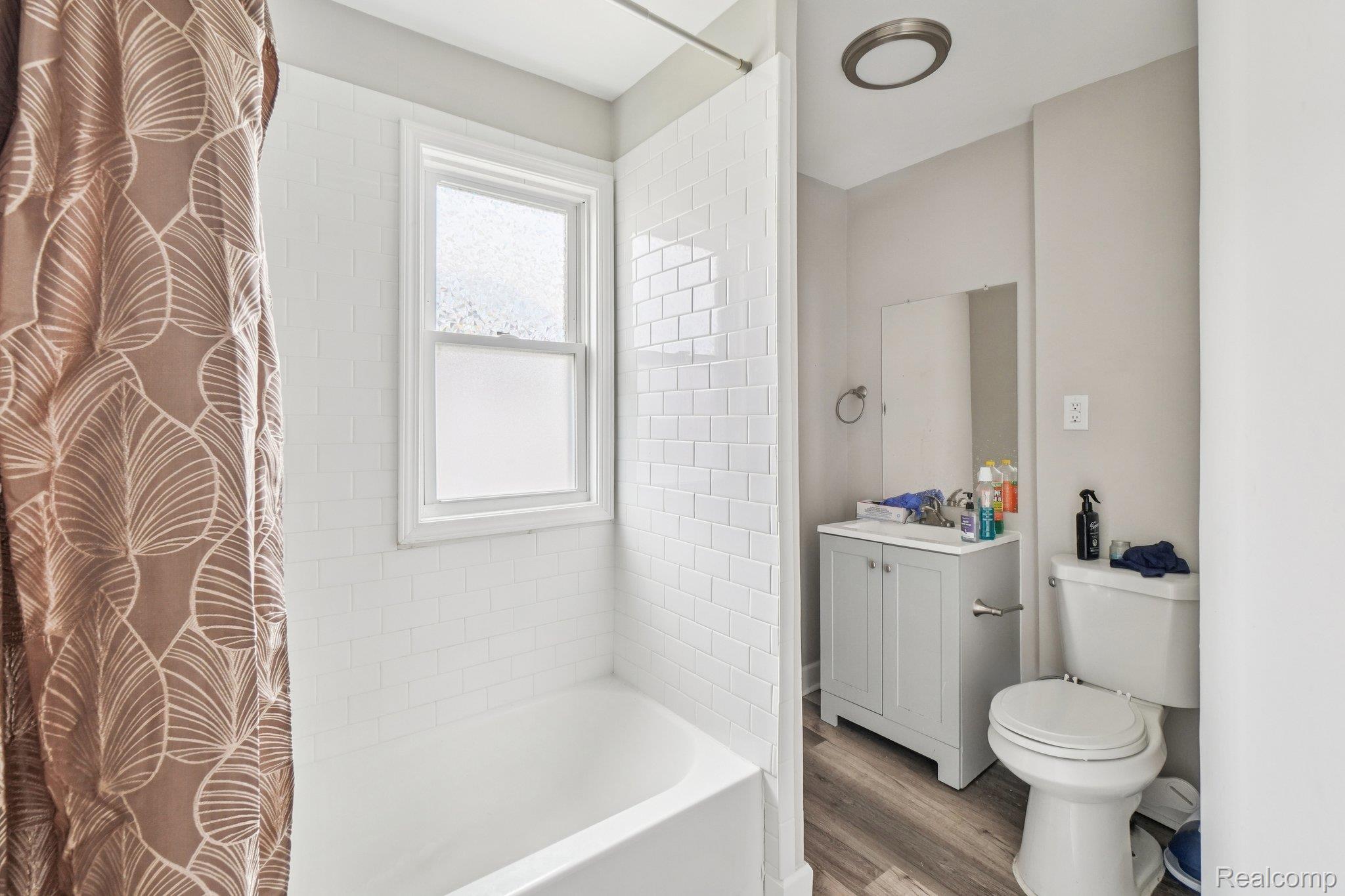 3822 Wabash Street Detroit, MI 48208 - Photo 13 of 17 Full bathroom featuring vanity, wood finished floors, and shower / bathtub combination with curtain