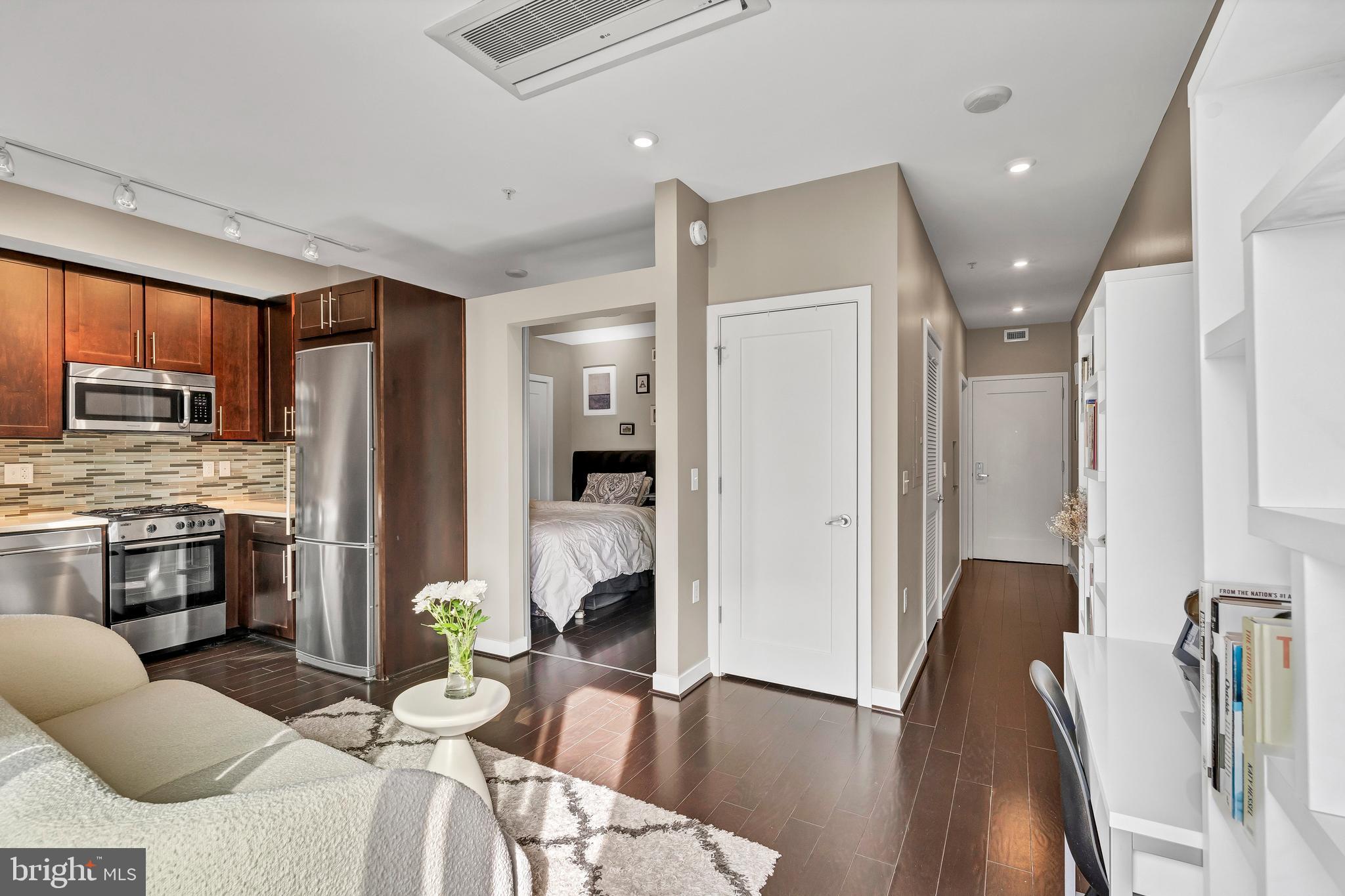 1320 Fenwick Lane, Unit 304 Silver Spring, MD 20910 - Photo 26 of 64 a living room with stainless steel appliances furniture a fireplace and a kitchen view