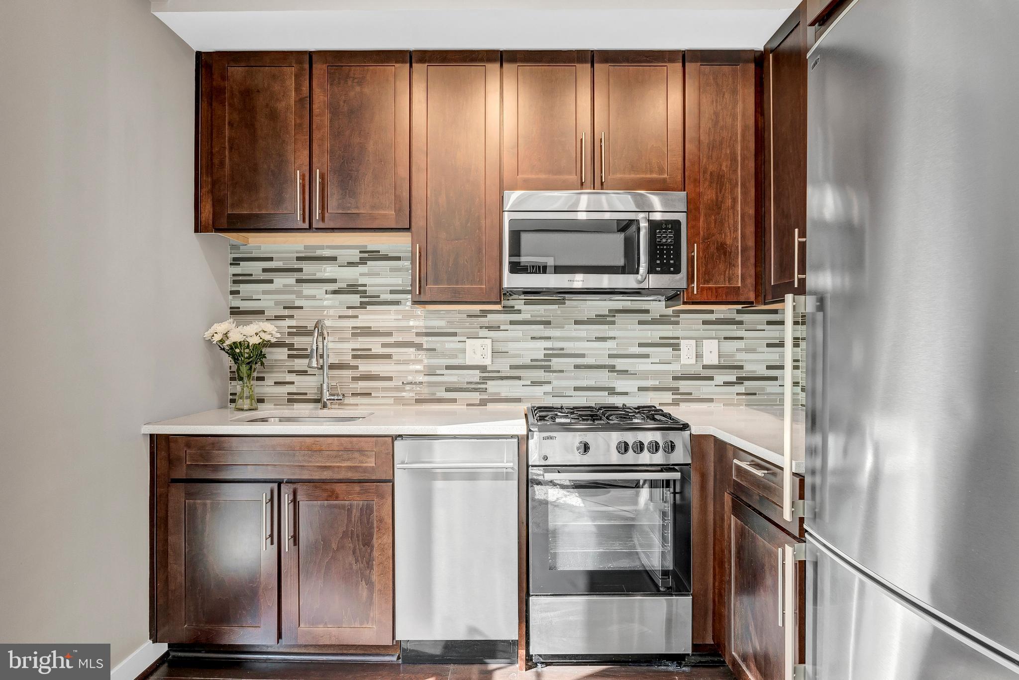 1320 Fenwick Lane, Unit 304 Silver Spring, MD 20910 - Photo 42 of 64 a kitchen with appliances a sink and cabinets