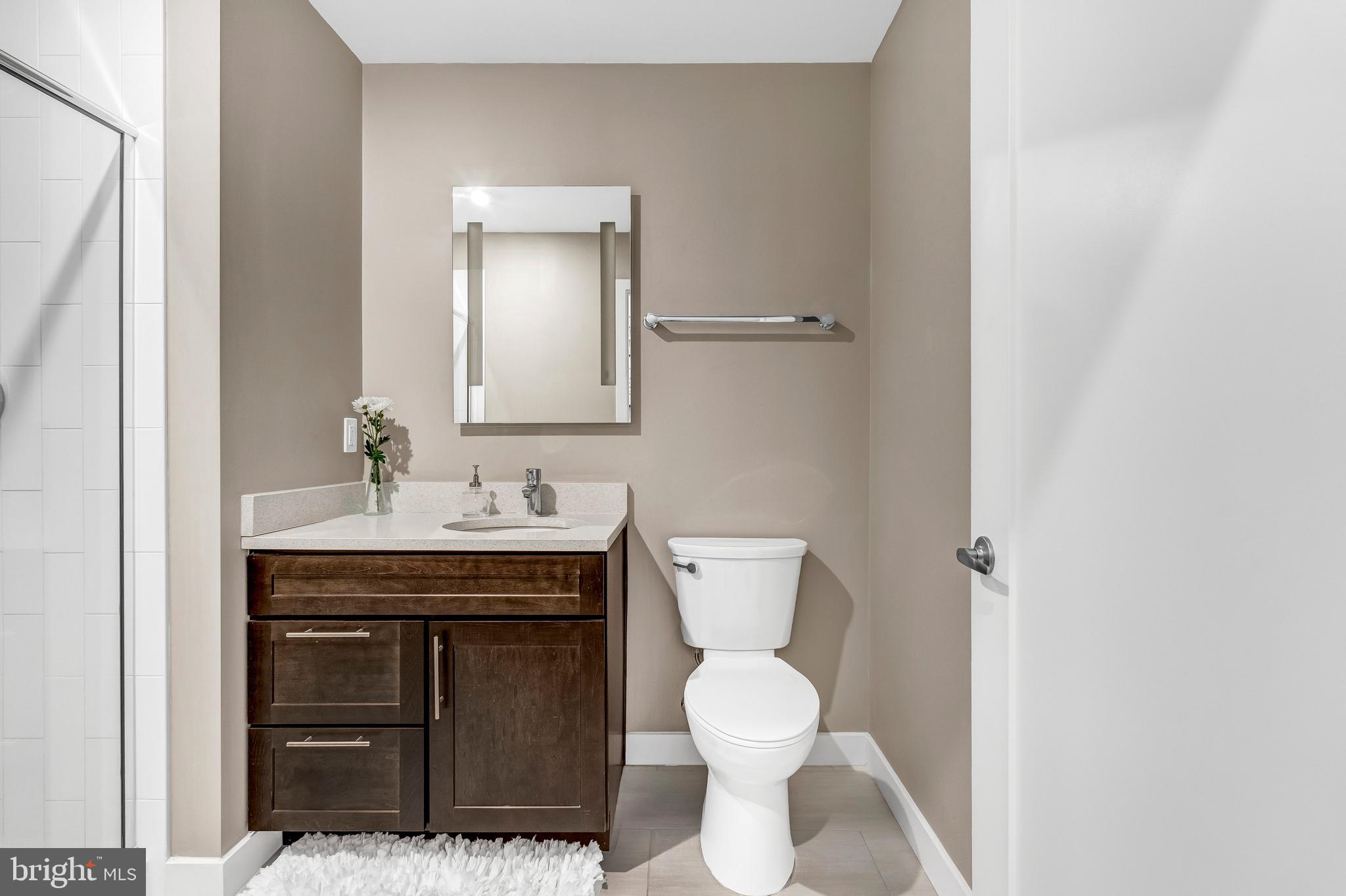 1320 Fenwick Lane, Unit 304 Silver Spring, MD 20910 - Photo 48 of 64 a bathroom with a toilet a sink and mirror
