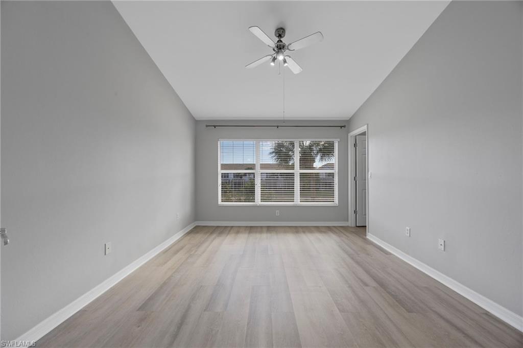 15930 Marcello Circle, Unit 242 Naples, FL 34110 - Photo 13 of 32 wooden floor in an empty room with a window