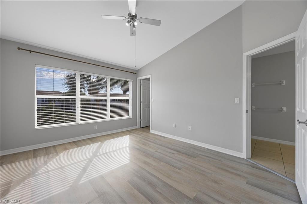 15930 Marcello Circle, Unit 242 Naples, FL 34110 - Photo 14 of 32 a view of an empty room with a window and wooden floor