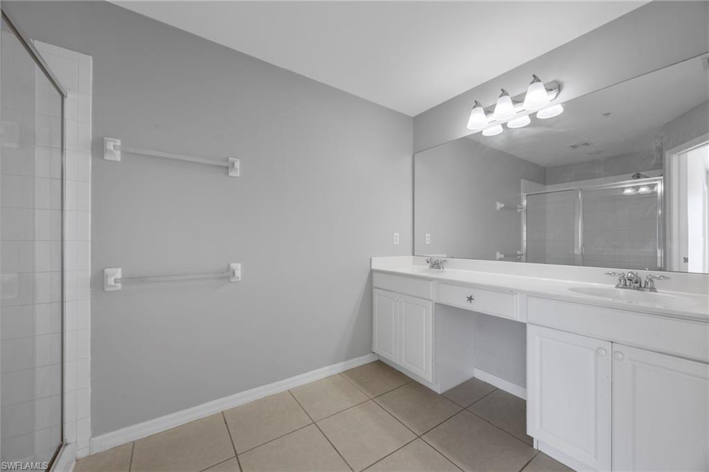 15930 Marcello Circle, Unit 242 Naples, FL 34110 - Photo 16 of 32 a bathroom with a sink vanity and a mirror