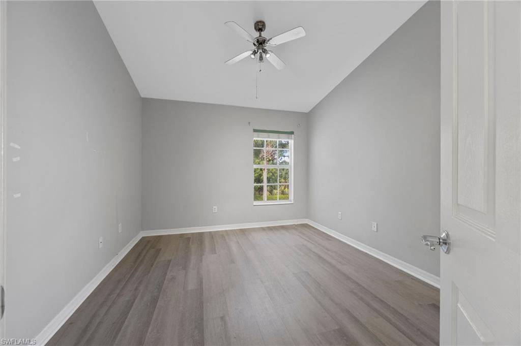 15930 Marcello Circle, Unit 242 Naples, FL 34110 - Photo 18 of 32 wooden floor in an empty room with a window