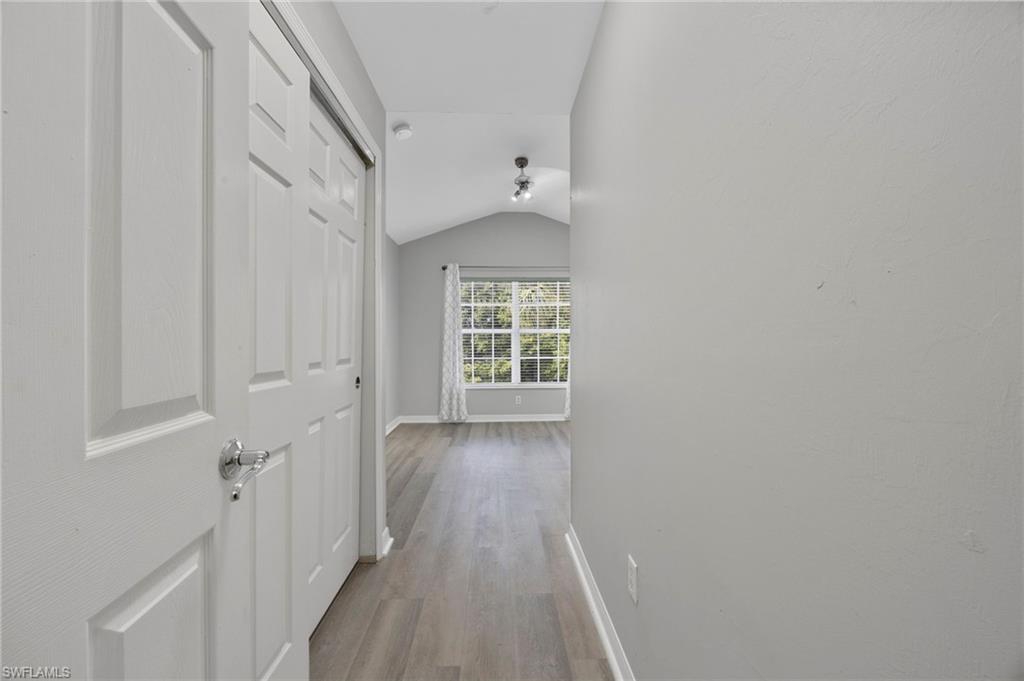 15930 Marcello Circle, Unit 242 Naples, FL 34110 - Photo 19 of 32 a view of a hallway with wooden floor and a window