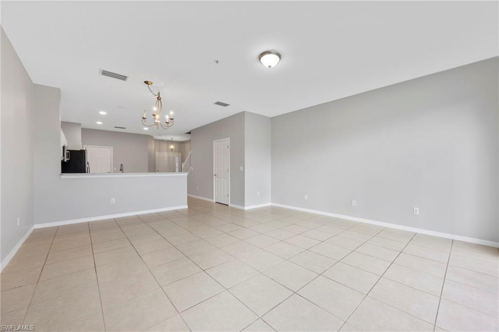 15930 Marcello Circle, Unit 242 Naples, FL 34110 - Photo 8 of 32 a view of an empty room and chandelier fan
