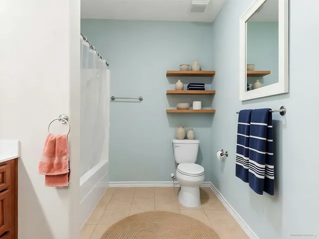 a bathroom with a toilet and a shower curtain