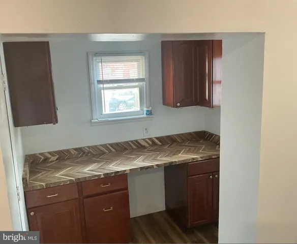 a utility room with granite countertop cabinets and sink