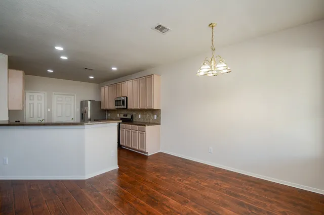 a kitchen with a refrigerator and a stove top oven