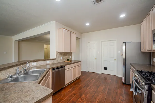 a kitchen with granite countertop a sink stove and refrigerator