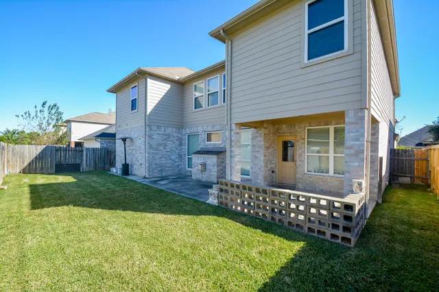 a view of a house with wooden fence and a yard
