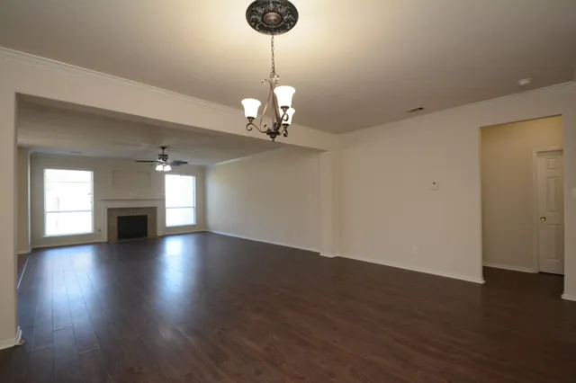 a view of empty room with wooden floor and fireplace