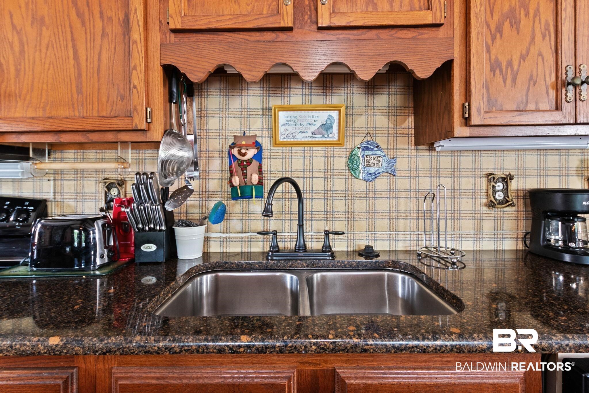 8153 Bryant's Lndg Road Stockton, AL 36579 - Photo 30 of 87 Dual basin stainless steel sink with a matte black faucet, set within a dark speckled countertop