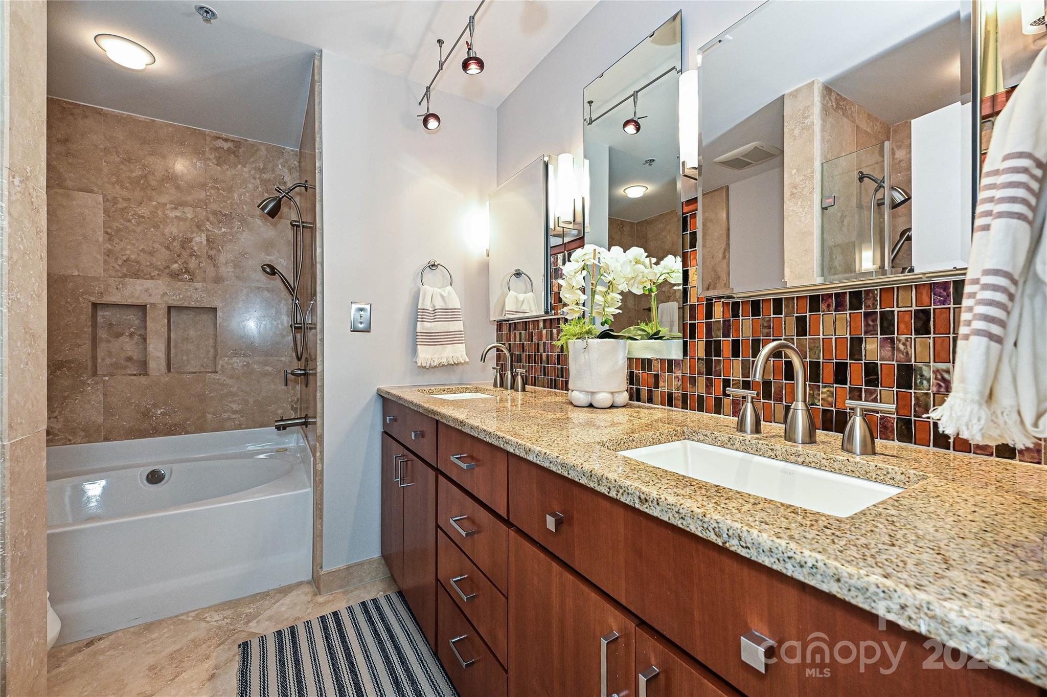 333 West 7th Street Charlotte, NC 28202 - Photo 29 of 46 a bathroom with a granite countertop tub a double vanity sink and a large mirror