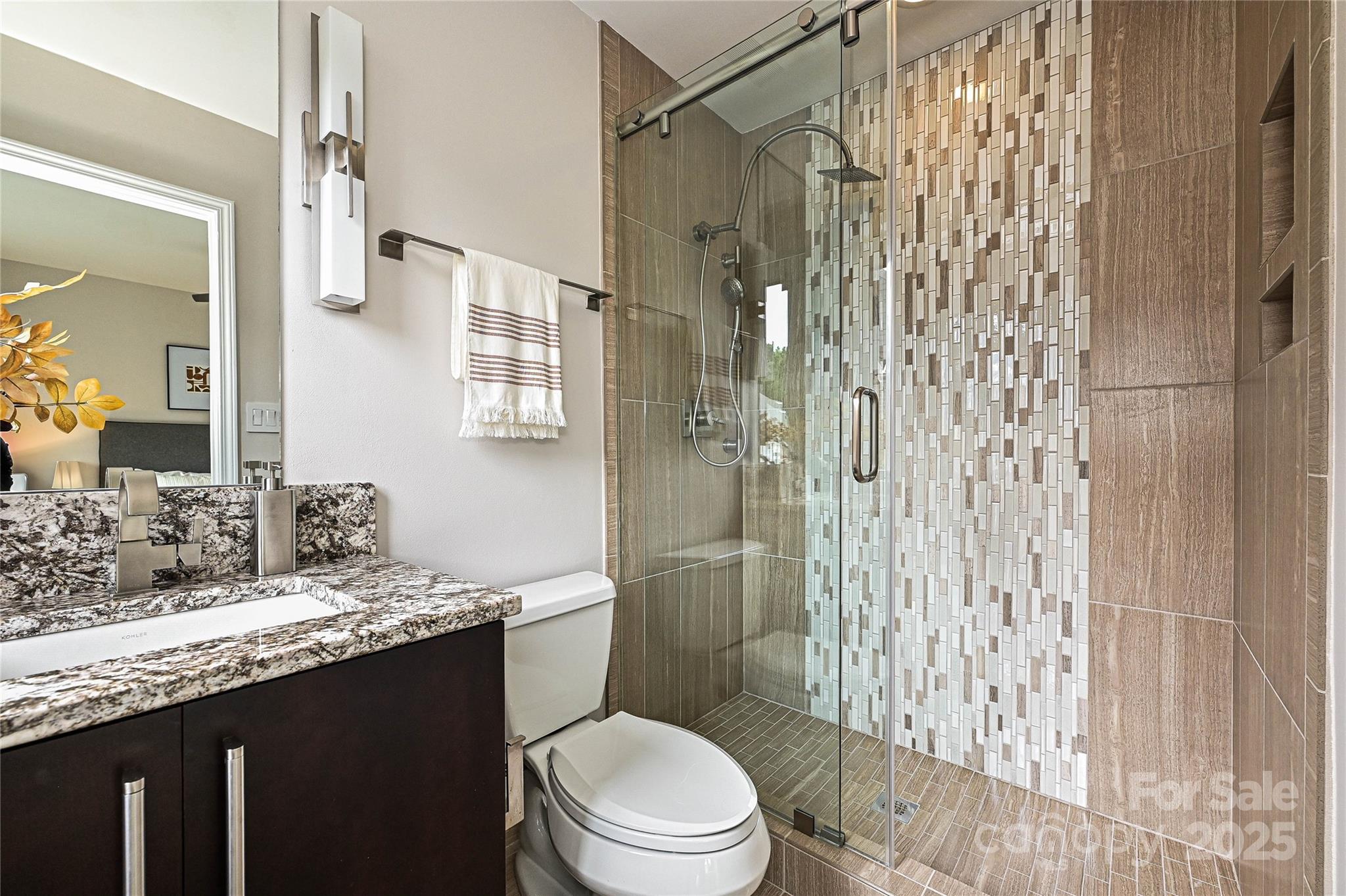 333 West 7th Street Charlotte, NC 28202 - Photo 34 of 46 a bathroom with a granite countertop sink toilet a mirror a vanity and shower