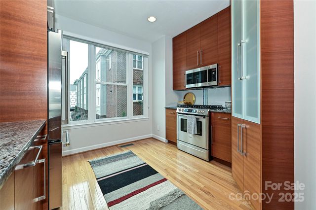 a kitchen with stainless steel appliances granite countertop a refrigerator and a sink