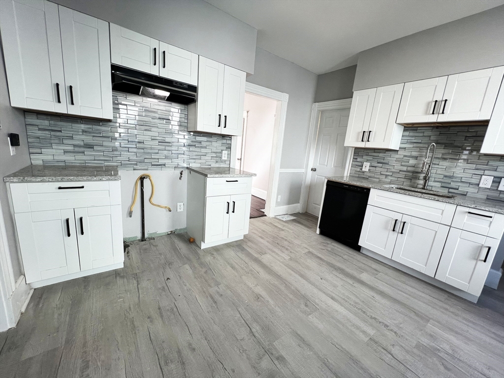 24 Wareham Street Springfield, MA 01108 - Photo 9 of 16 a kitchen with white cabinets a sink stove and white stainless steel appliances