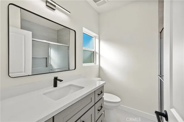 a bathroom with a sink a toilet and mirror