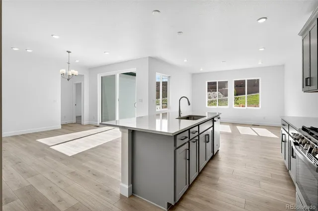a kitchen with stainless steel appliances granite countertop a sink and a wooden floors