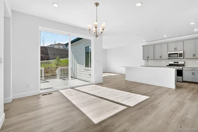 a view of kitchen with granite countertop cabinets and refrigerator