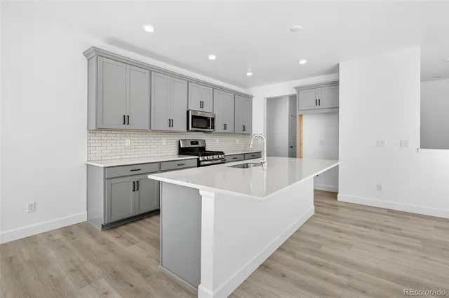 a kitchen with kitchen island white cabinets and stainless steel appliances