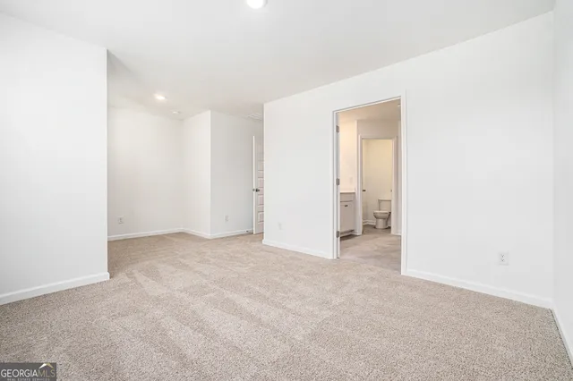 a view of an empty room with closet and a window