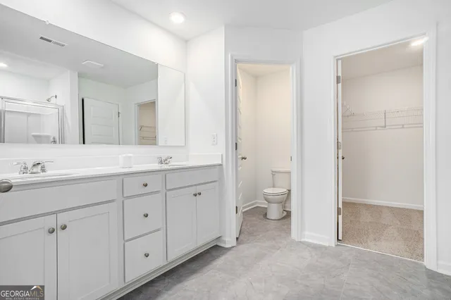 a spacious bathroom with a granite countertop sink a toilet and a shower