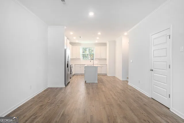 a view of a kitchen with wooden floor and a refrigerator