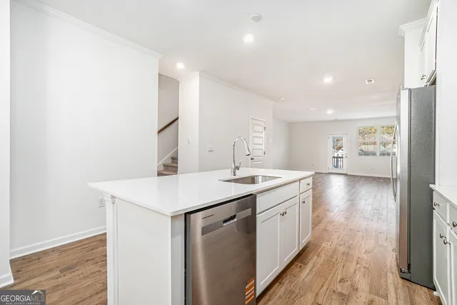 a kitchen with a sink stove and wooden floor
