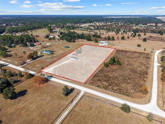a kitchen with stainless steel appliances a table chairs and wooden floor