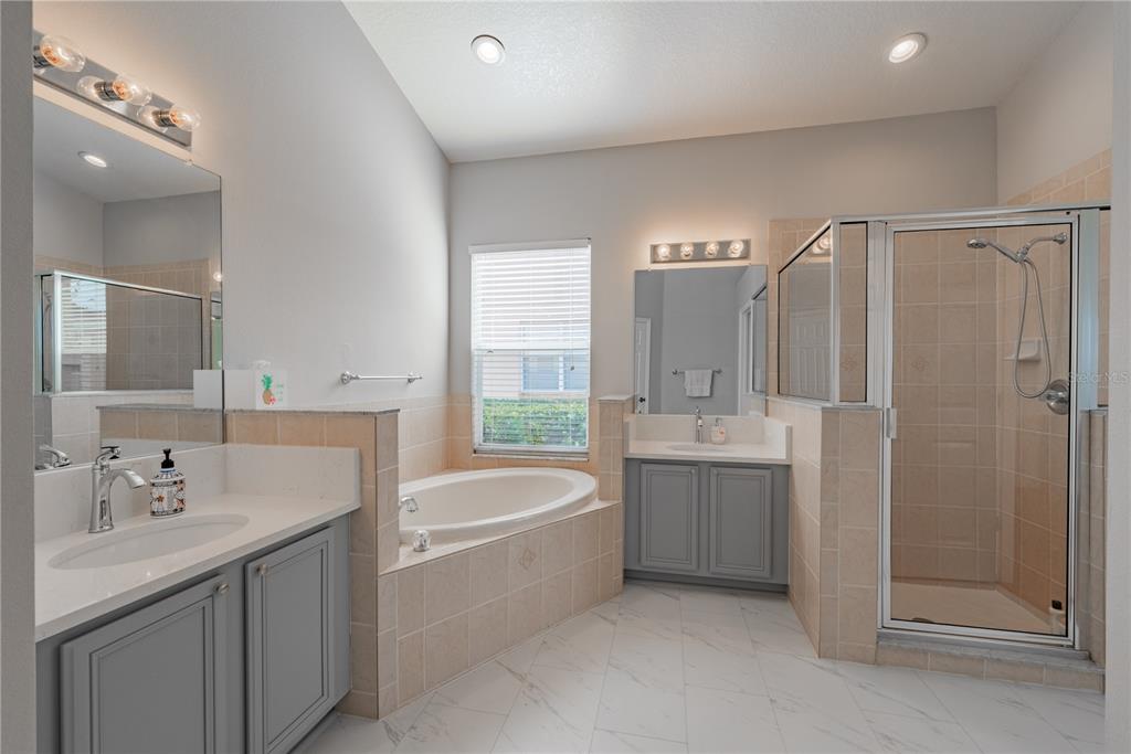 18028 Java Isle Drive Tampa, FL 33647 - Photo 25 of 53 a bathroom with a tub sink shower and mirror