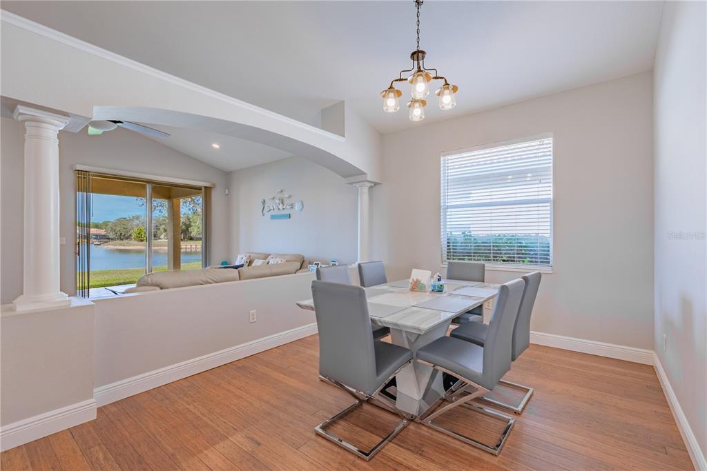 18028 Java Isle Drive Tampa, FL 33647 - Photo 30 of 53 a dining room with wooden floor and a chandelier