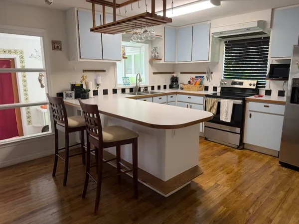 a kitchen with stainless steel appliances a table chairs and a refrigerator