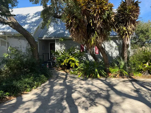 a front view of a house with a tree