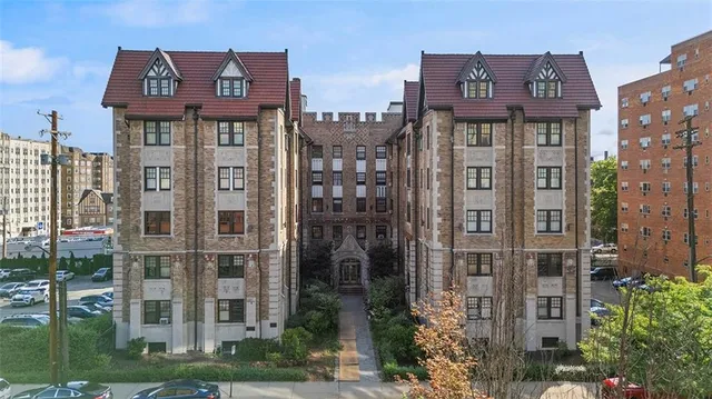 a front view of a residential apartment building with a yard and plants