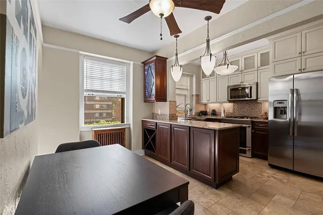 a kitchen with stainless steel appliances granite countertop a sink a stove counter space and cabinets