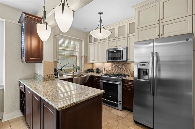 a kitchen with stainless steel appliances granite countertop a sink a stove a refrigerator and a microwave
