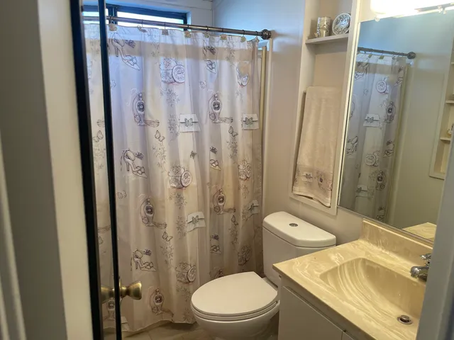 a bathroom with a granite countertop toilet a sink and a shower