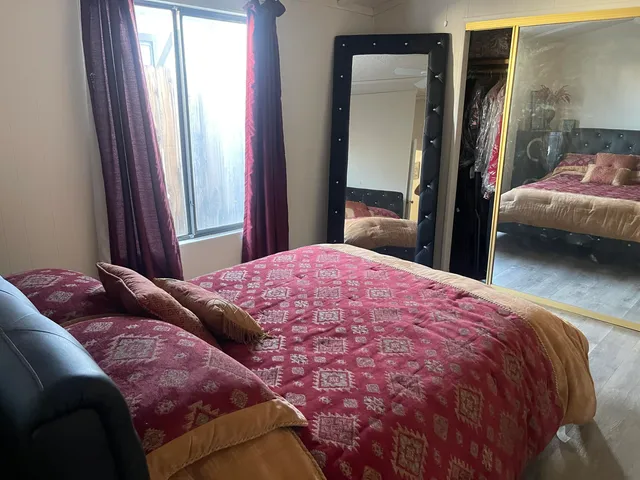 a bedroom with a bed and a mirror